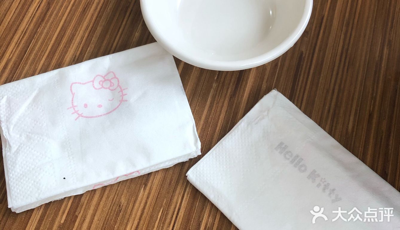 向我递出她的两张Hello Kitty餐巾纸