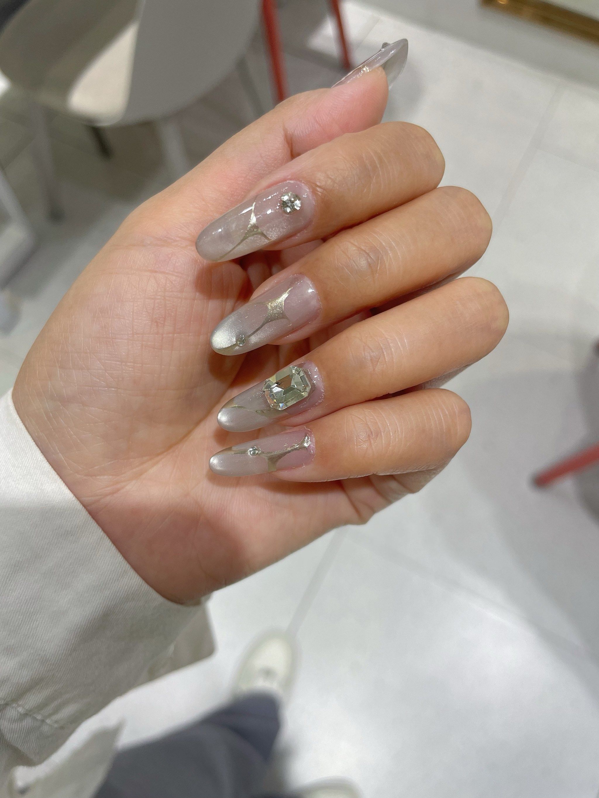 每一根指甲都打磨得完美无瑕,椭圆形的形状显得手指更加修长