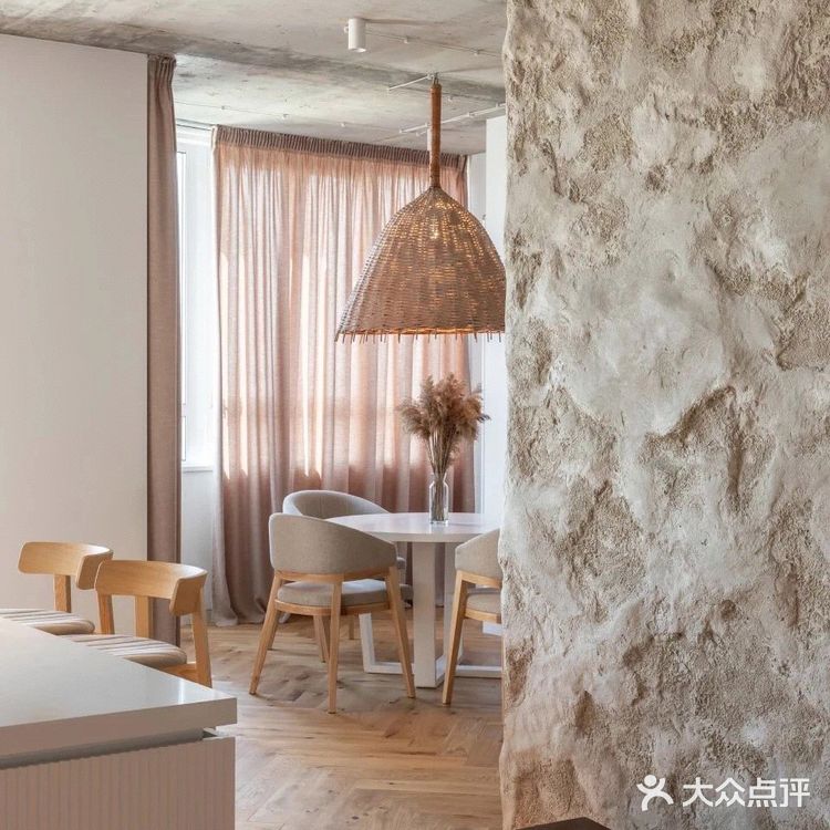 餐厅位于落地窗旁，光线透过暖色窗帘照入室内