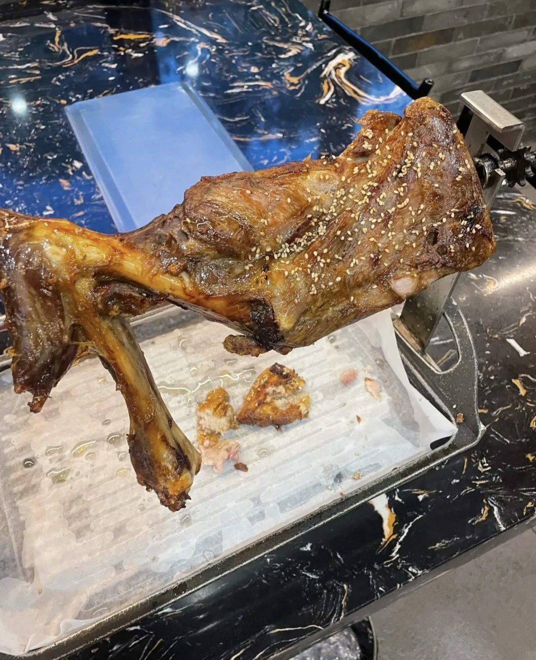 烤羊腿的皮很脆里面的肉很嫩吃起来有很多汁不会觉得干也没有羊的