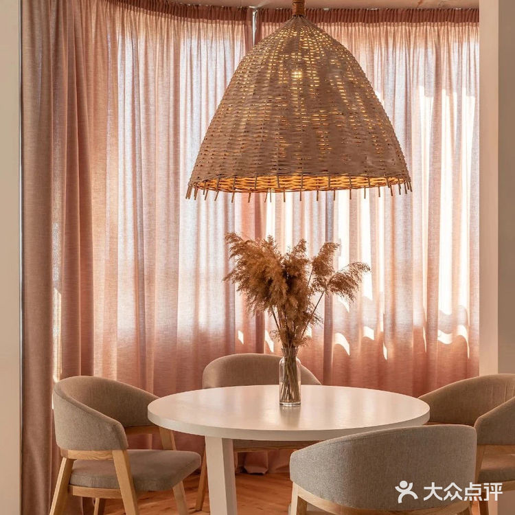 餐厅位于落地窗旁，光线透过暖色窗帘照入室内