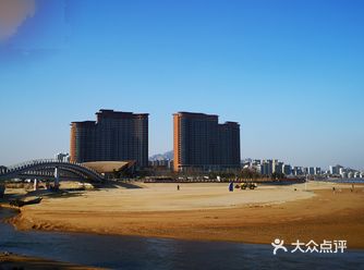 广场上有放风筝的海边有很多人漫步，环天气好的时候