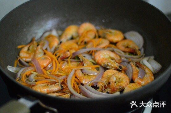 放入虾，用煎炸的方式铺平煎制，一面煎至焦黄后