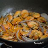 放入虾，用煎炸的方式铺平煎制，一面煎至焦黄后