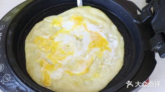 用手将饼皮摊平，盖锅焖上一分钟。一分钟后打开翻面
