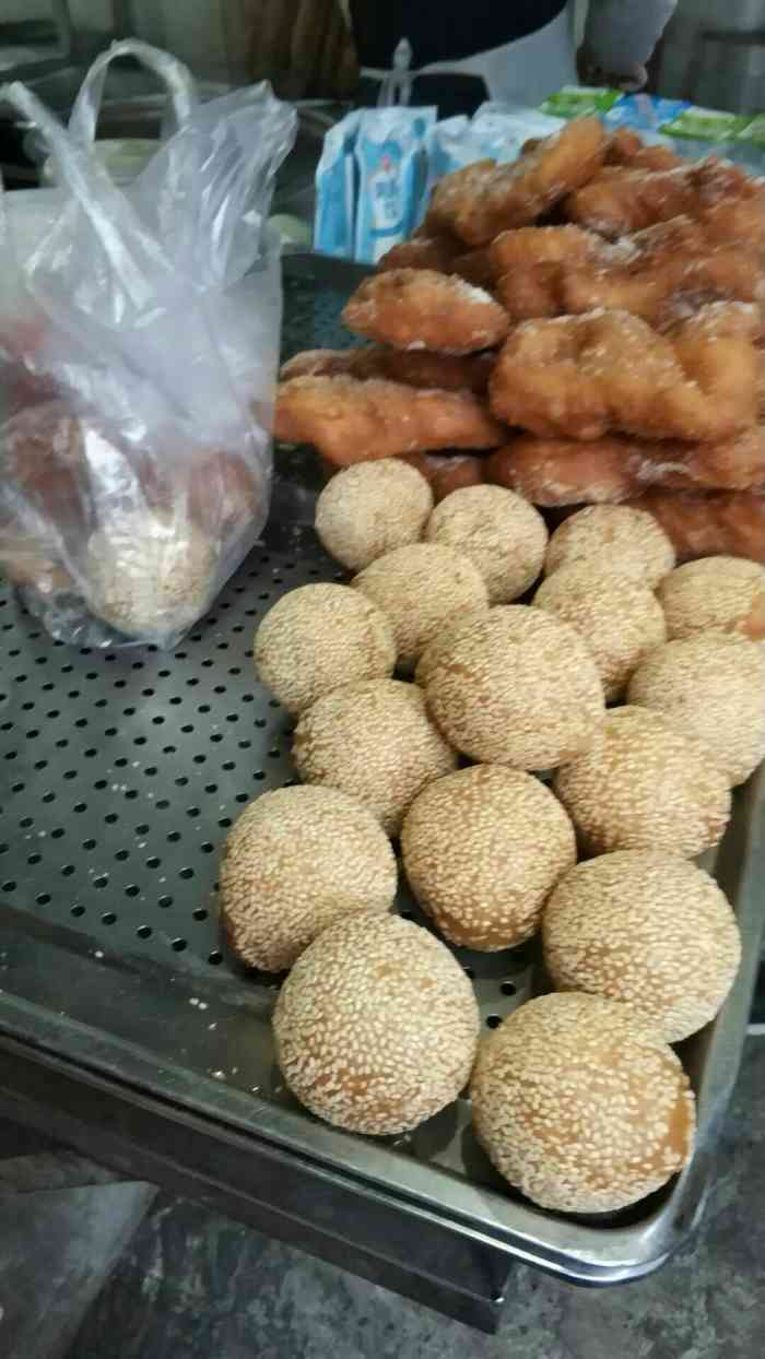 一家小店早上生意很好附近有公交站台等车吃早餐的人