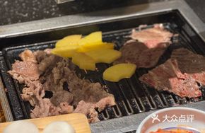 Staff Assists with Grilling Meat