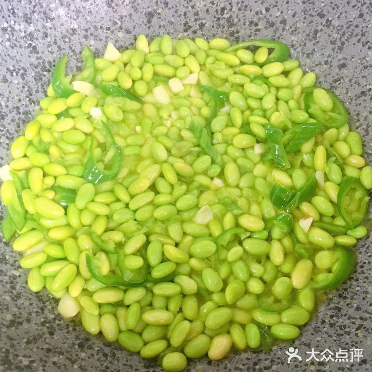 再放入青椒，炒出辣味，接着倒入毛豆，翻炒均匀