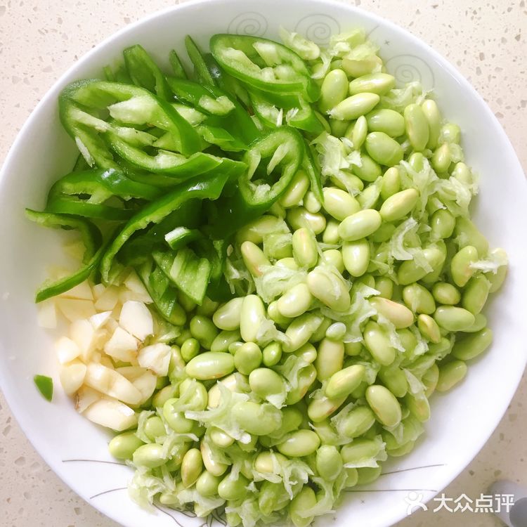 再放入青椒，炒出辣味，接着倒入毛豆，翻炒均匀