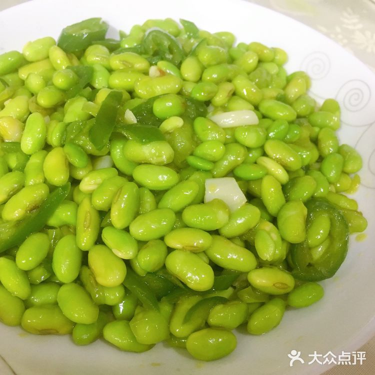 再放入青椒，炒出辣味，接着倒入毛豆，翻炒均匀
