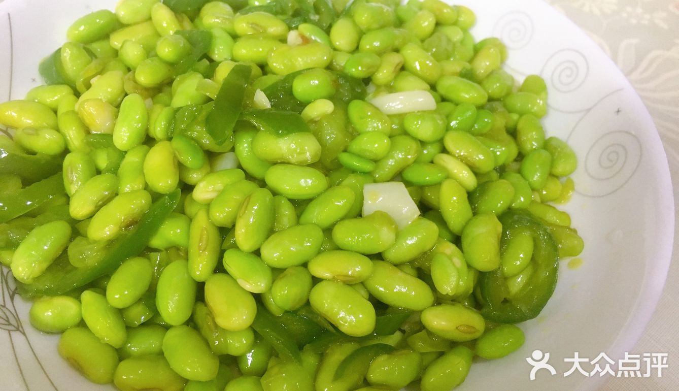 再放入青椒，炒出辣味，接着倒入毛豆，翻炒均匀
