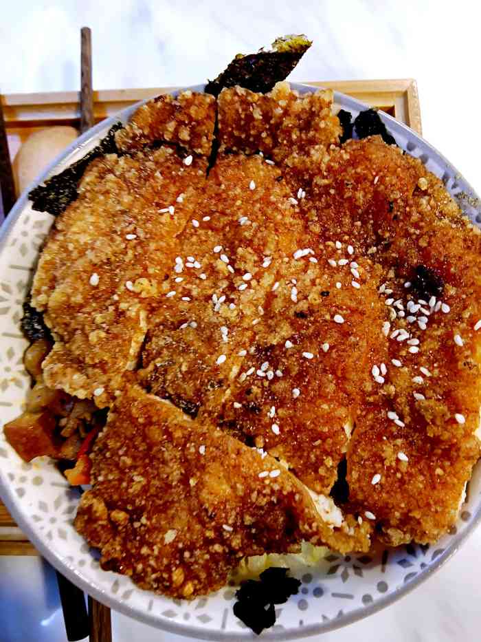 鸡排上浇了酱汁,下面又铺了海苔,再下面是豆腐干,榨菜,肉丁等炒的酱