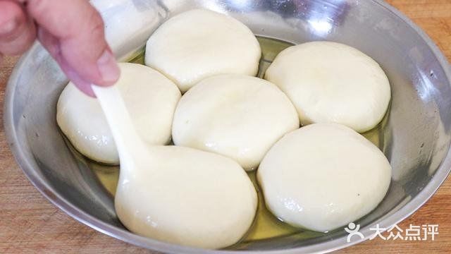 用手将饼皮摊平，盖锅焖上一分钟。一分钟后打开翻面