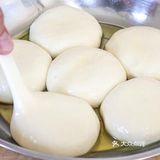 用手将饼皮摊平，盖锅焖上一分钟。一分钟后打开翻面