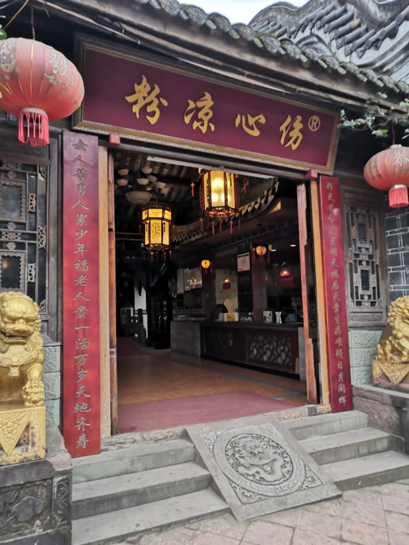 街上两家"伤心凉粉"店正对着,装修风格一致,实际就是一家,可能生意太