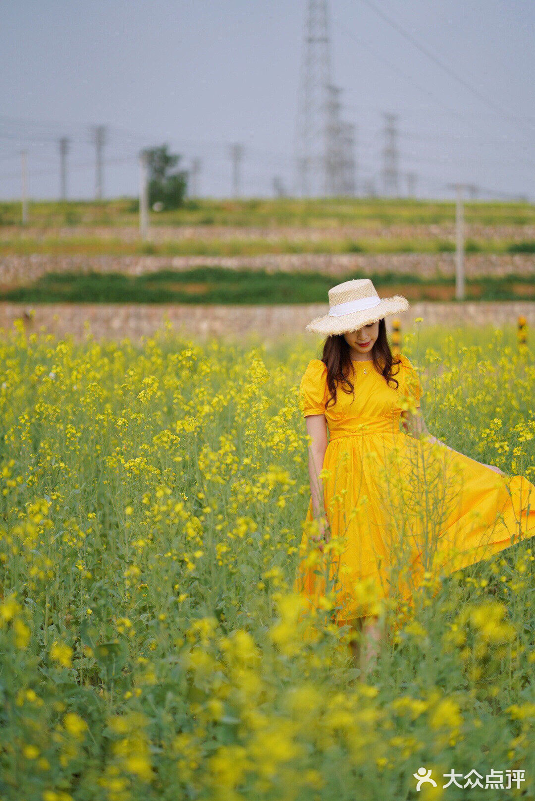 油菜花地拍照穿驼色图片