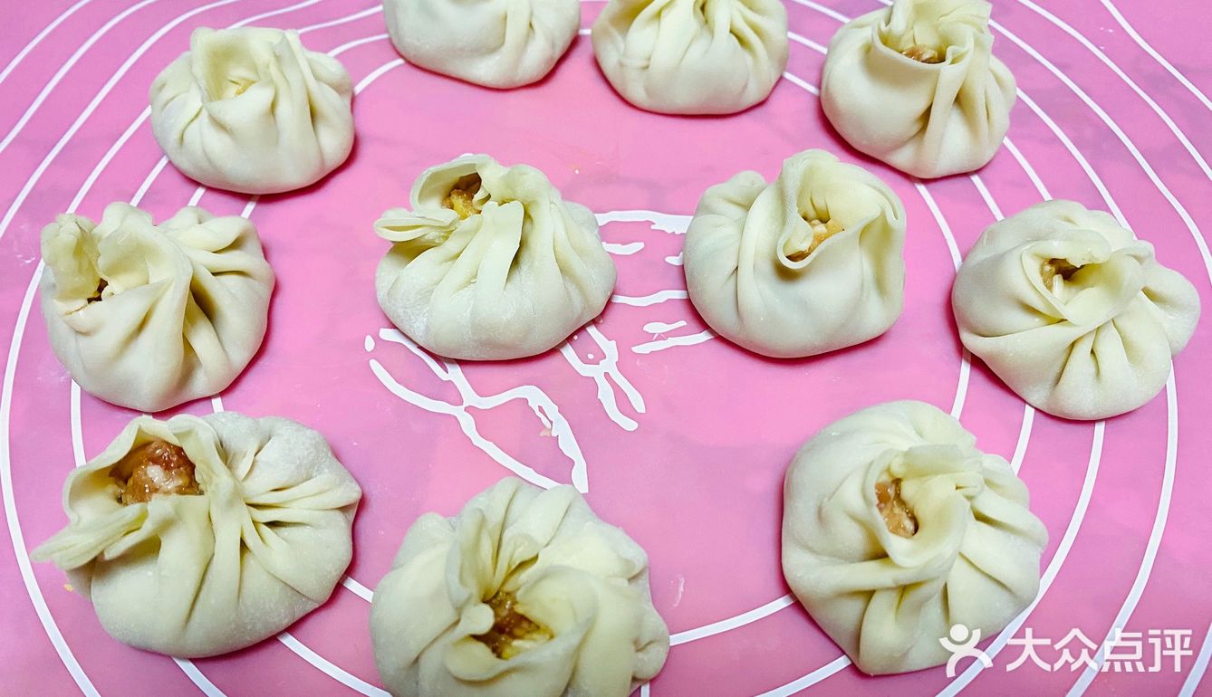 每个饺子皮中间放入肉末，大拇指按住一个方向打折成一圈