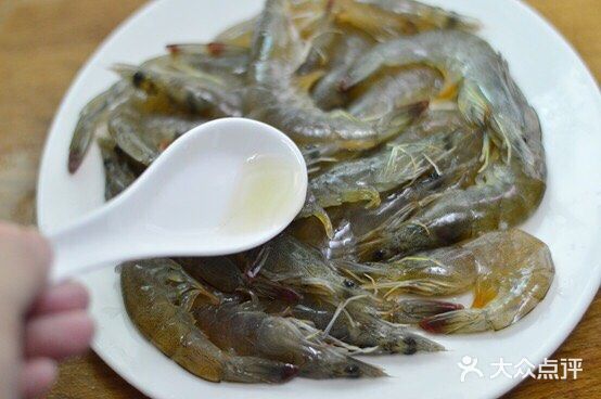 放入虾，用煎炸的方式铺平煎制，一面煎至焦黄后