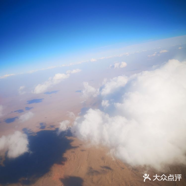 天空很蓝，几朵白云就像是画上去似的，天空和白云都很干净